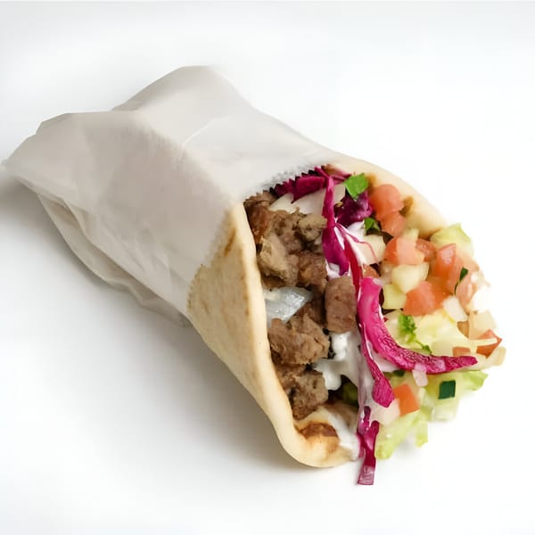 A Flaming Bites Halal Grill gyro, filled with meat, white sauce, red cabbage, and diced vegetables.