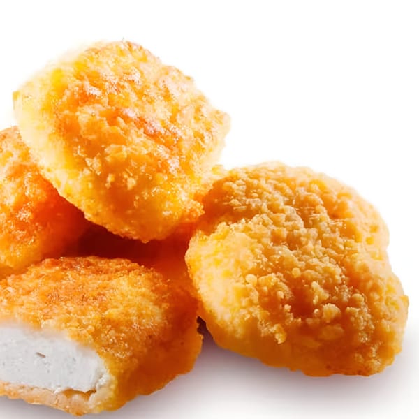 A close-up of golden-brown, breaded halal chicken nuggets, one cut open to show the white meat inside.